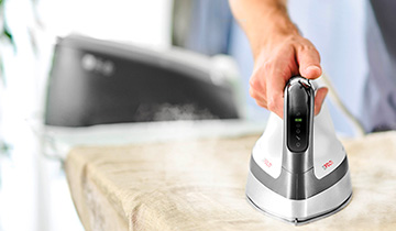 The image shows a man who is ironing a linen shirt